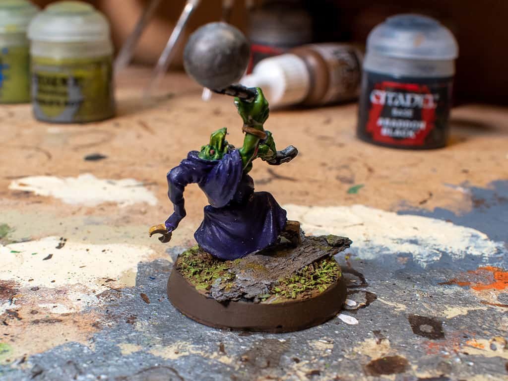 A gloomspite Git painted with a purple robe, but the basecoat was too thick when applied