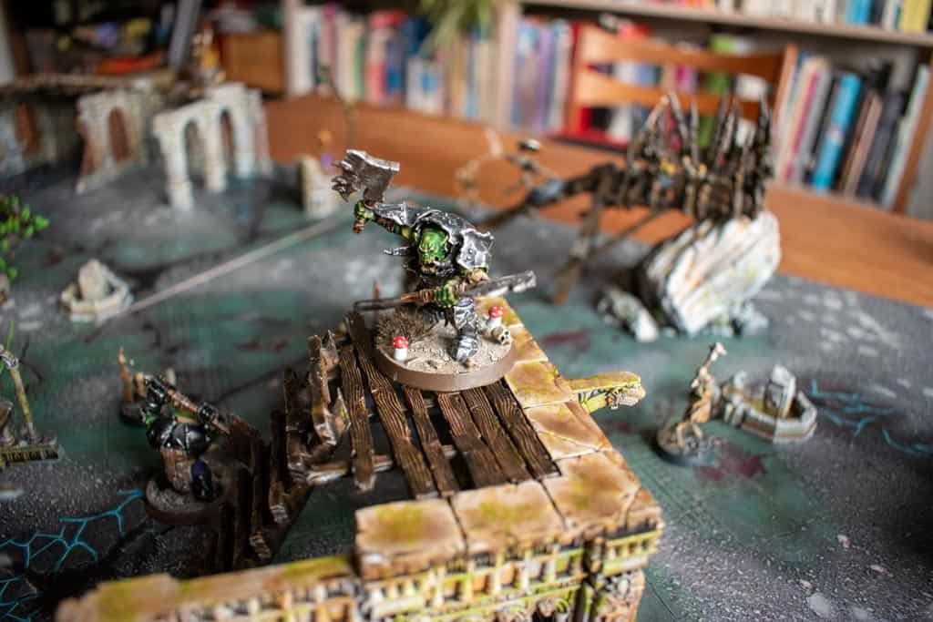 In Ironjawz Brute with black armour standing on a platform of some warcry terrain