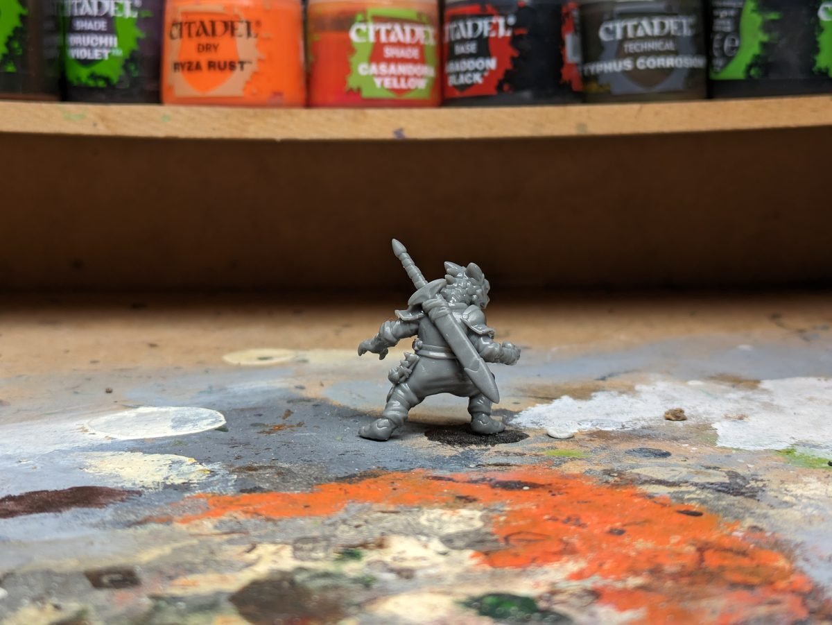 Freshly 3D printed miniature on a hobby desk next to Citadel paints