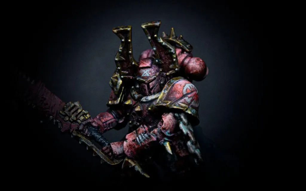 Weathered and beaten Khorne warrior. Hos red and gold armour is painted by doing stippling with a sponge and other teqchniques.